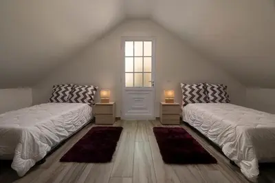 two beds in a room with a window and two lamps at Casa Tiana Madeira in Ponta do Sol