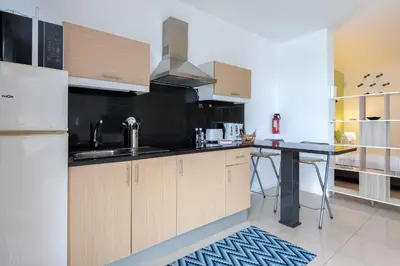 a kitchen with wooden cabinets and a black counter top at The Little Nest by LovelyStay in Ponta do Sol