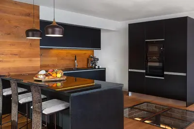 a kitchen with black cabinets and a table with fruit on it at Fazendinha by Real Vision in Gaula