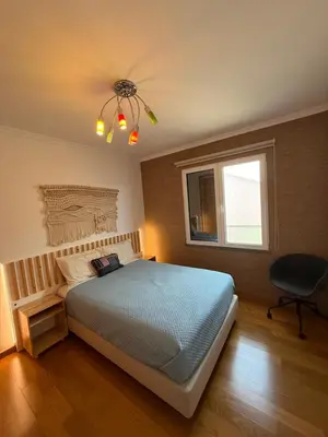 a bedroom with a bed with pillows and a window at Tamariz Adventure - Sea View and Free Parking in Caniço