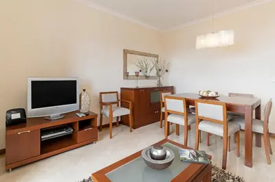 a living room with a television and a dining room at Ajuda III by An Island Apart in Funchal