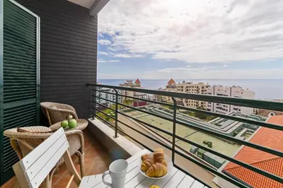 a balcony with a table and a view of the ocean at Ajuda III by An Island Apart in Funchal