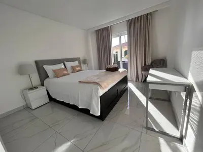 a white bedroom with a bed and a desk at Ocean Dream Apartment- Air Condition in Funchal