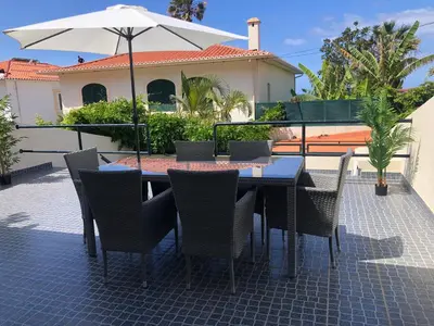 a table with chairs and an umbrella on a patio at Ocean Dream Apartment- Air Condition in Funchal