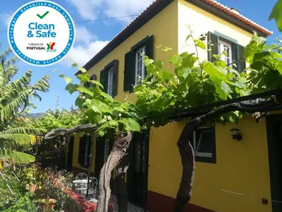 a yellow house with a tree in front of it at Casa D`Avó Celina in Funchal