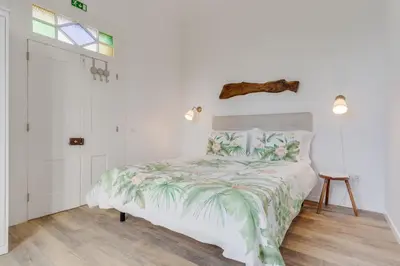 a bedroom with a bed with a green and white comforter at Casa D`Avó Celina in Funchal