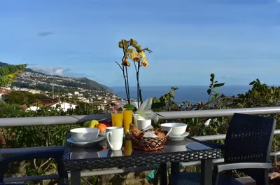 a table with a basket of fruit on a balcony at Casa do Avô Ladeira in Estreito da Calheta
