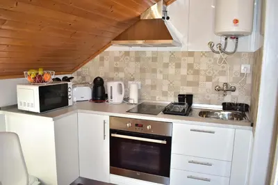 a small kitchen with a sink and a microwave at Casa do Avô Ladeira in Estreito da Calheta
