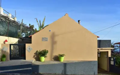 a house with two potted plants in front of it at Casa do Avô Ladeira in Estreito da Calheta