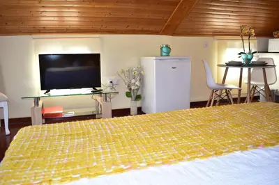 a bedroom with a large bed and a flat screen tv at Casa do Avô Ladeira in Estreito da Calheta