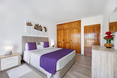 a bedroom with a large bed with purple pillows at Apartamento Navegador in Sagres