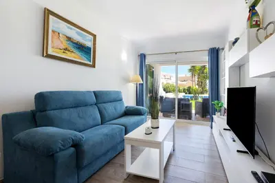 a living room with a blue couch and a tv at Apartamento Navegador in Sagres