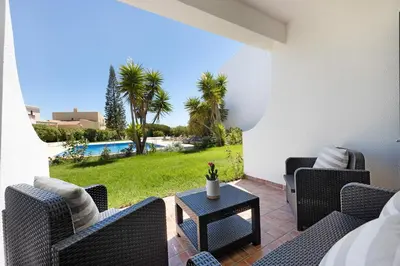 a patio with chairs and a table and a pool at Apartamento Navegador in Sagres