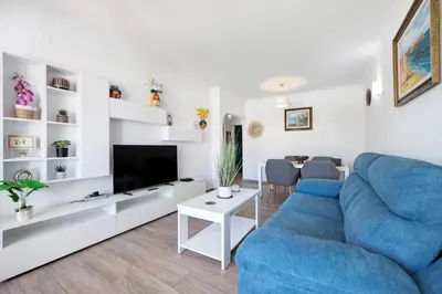 a living room with a blue couch and a tv at Apartamento Navegador in Sagres
