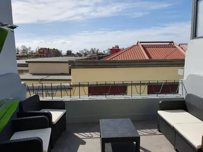 a balcony with chairs and tables on a building at Agnelo Comfort - Accommodation H V in Funchal