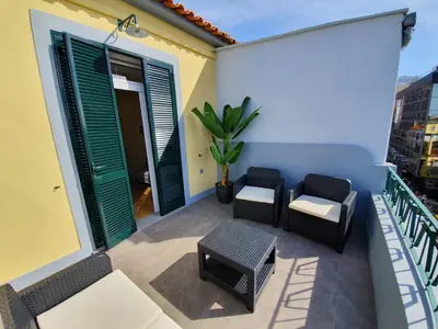 a balcony with chairs and a table and a plant at Agnelo Comfort - Accommodation H V in Funchal
