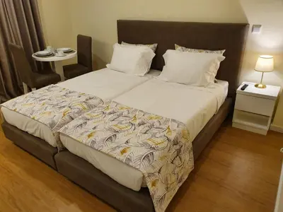 a bedroom with a large bed with white sheets at Agnelo Comfort - Accommodation H V in Funchal