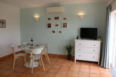 a dining room with a table and chairs and a television at Lagos 61 in Lagos
