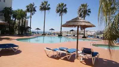 a swimming pool with lounge chairs and an umbrella at Lagos 61 in Lagos
