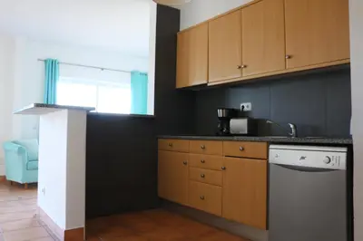 a kitchen with wooden cabinets and a dishwasher at Lagos 61 in Lagos