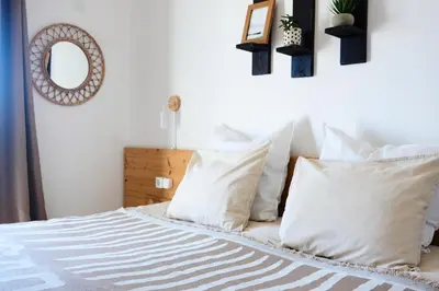 a bedroom with a bed with white pillows and a mirror at Algarve Surf Camp & Hostel Sagres in Sagres
