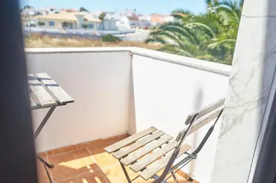 a wooden bench sitting on a balcony with a view at Algarve Surf Camp & Hostel Sagres in Sagres