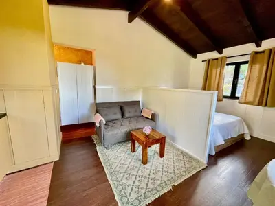 a living room with a couch and a table at Palheiro do Avô in Santa Cruz