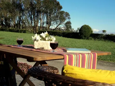 a picnic table with two glasses of wine on it at Palheiro do Avô in Santa Cruz