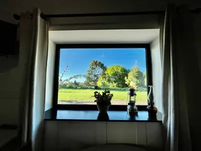a window with a view of a green field at Palheiro do Avô in Santa Cruz