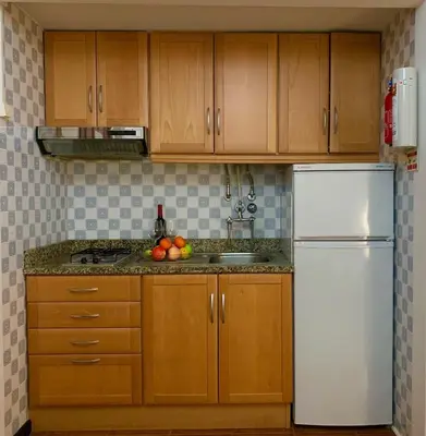 a kitchen with wooden cabinets and a white refrigerator at Black & White by Homie in Funchal