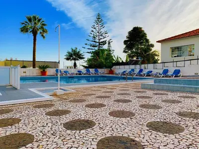 a swimming pool with blue chairs and a tile floor at Black & White by Homie in Funchal