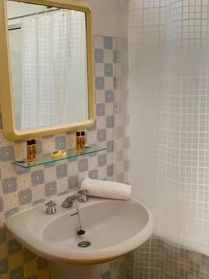 a bathroom with a white sink and a mirror at Black & White by Homie in Funchal