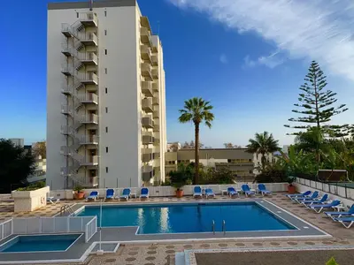 a swimming pool with chairs and a building at Black & White by Homie in Funchal