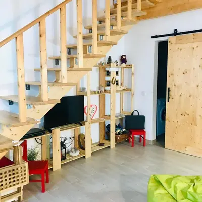 a living room with a wooden spiral staircase at CASA BIKAS in Barão de São Miguel