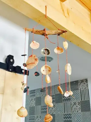 a chandelier made out of shells hanging from a ceiling at CASA BIKAS in Barão de São Miguel