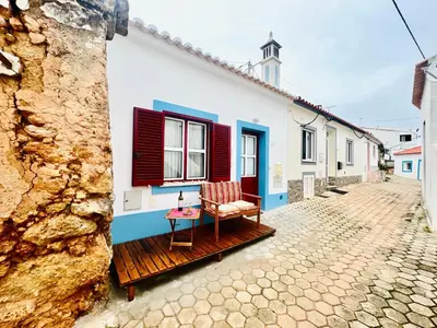 a house with red and blue shutters on a street at CASA BIKAS in Barão de São Miguel