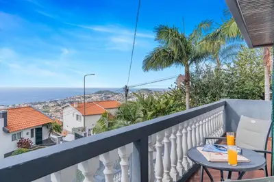 a balcony with a table and a view of the ocean at Cumbres Villa in Funchal