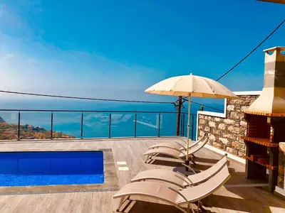 a bedroom with a large bed with a large window at Villa da Bisa with heated swiming pool in Arco da Calheta