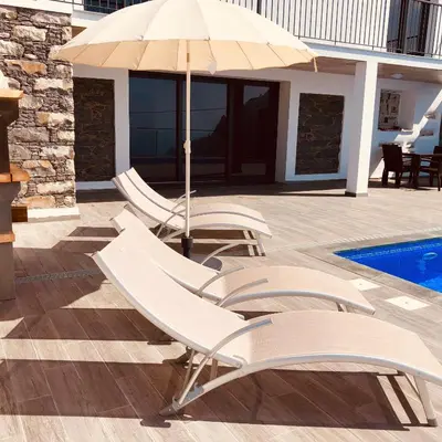 a table with plates and wine glasses on it at Villa da Bisa with heated swiming pool in Arco da Calheta