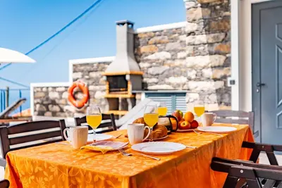 a dining room with a table and chairs and a fireplace at Villa da Bisa with heated swiming pool in Arco da Calheta