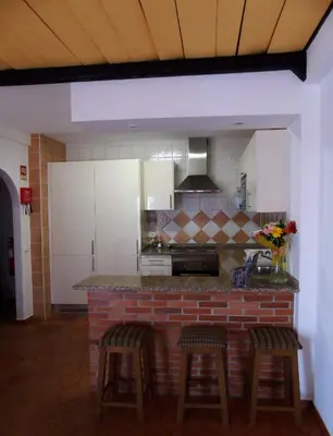 a kitchen with a counter and stools in a room at Cantinho Das Estrelas, Luz Lagos in Luz