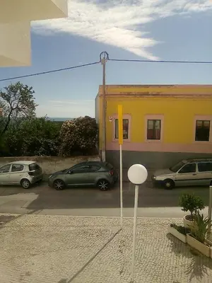 two cars parked in a parking lot next to a building at Cantinho Das Estrelas, Luz Lagos in Luz
