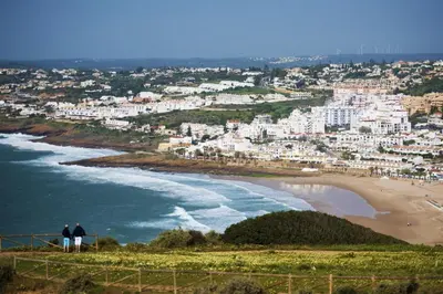 two people standing on a hill overlooking a beach at Calheta House in Luz in Luz