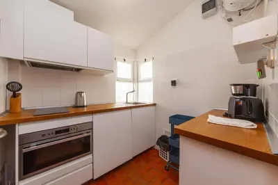 a kitchen with white cabinets and a counter top at Calheta House in Luz in Luz