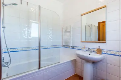 a bathroom with a sink and a shower at Salema Family Home in Salema