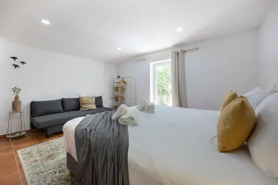 a bedroom with a large white bed and a couch at Salema Family Home in Salema