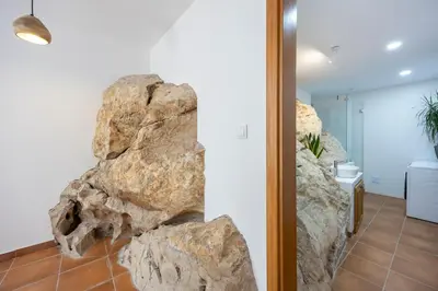 a room with a large rock on the wall at Salema Family Home in Salema