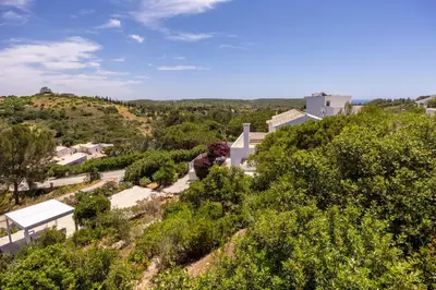 an aerial view of a hill with trees and houses at Salema Family Home in Salema