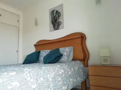 a bed with two blue pillows in a bedroom at Burgau125 - villa near the beach in Vila do Bispo