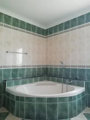 a bath tub in a bathroom with green tiles at Burgau125 - villa near the beach in Vila do Bispo